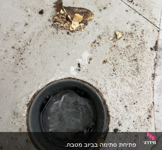 ניקוז סתום עם לכלוך ופסולת על הרצפה